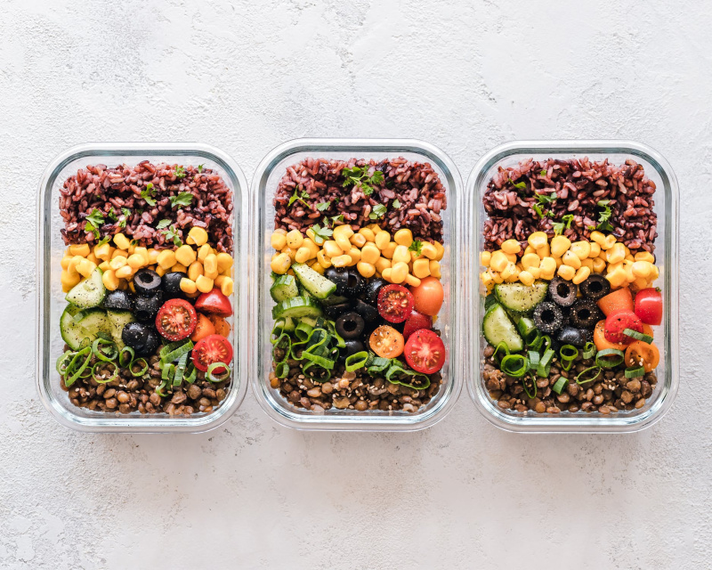 Three baking dishes filled with fresh vegetables sit next to one another