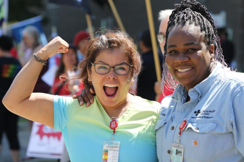 Two women, one pumping her first, excited at a rally