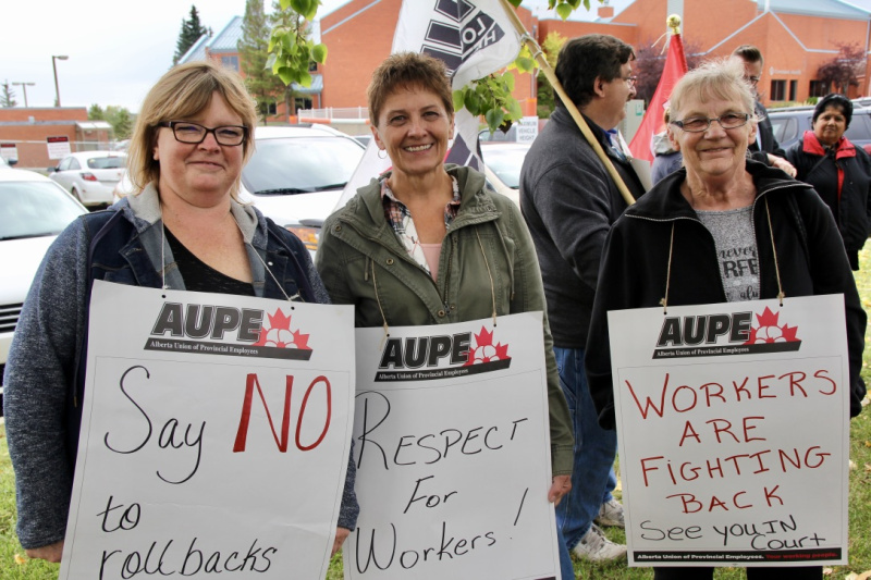 Three AUPE members smile for the camera at a picket line in Camrose.